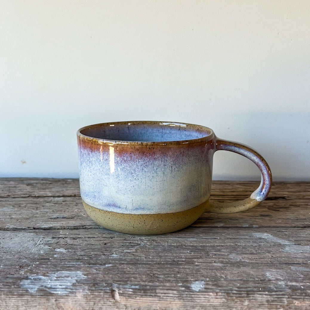 Ceramic mug with a speckled design on a wooden surface