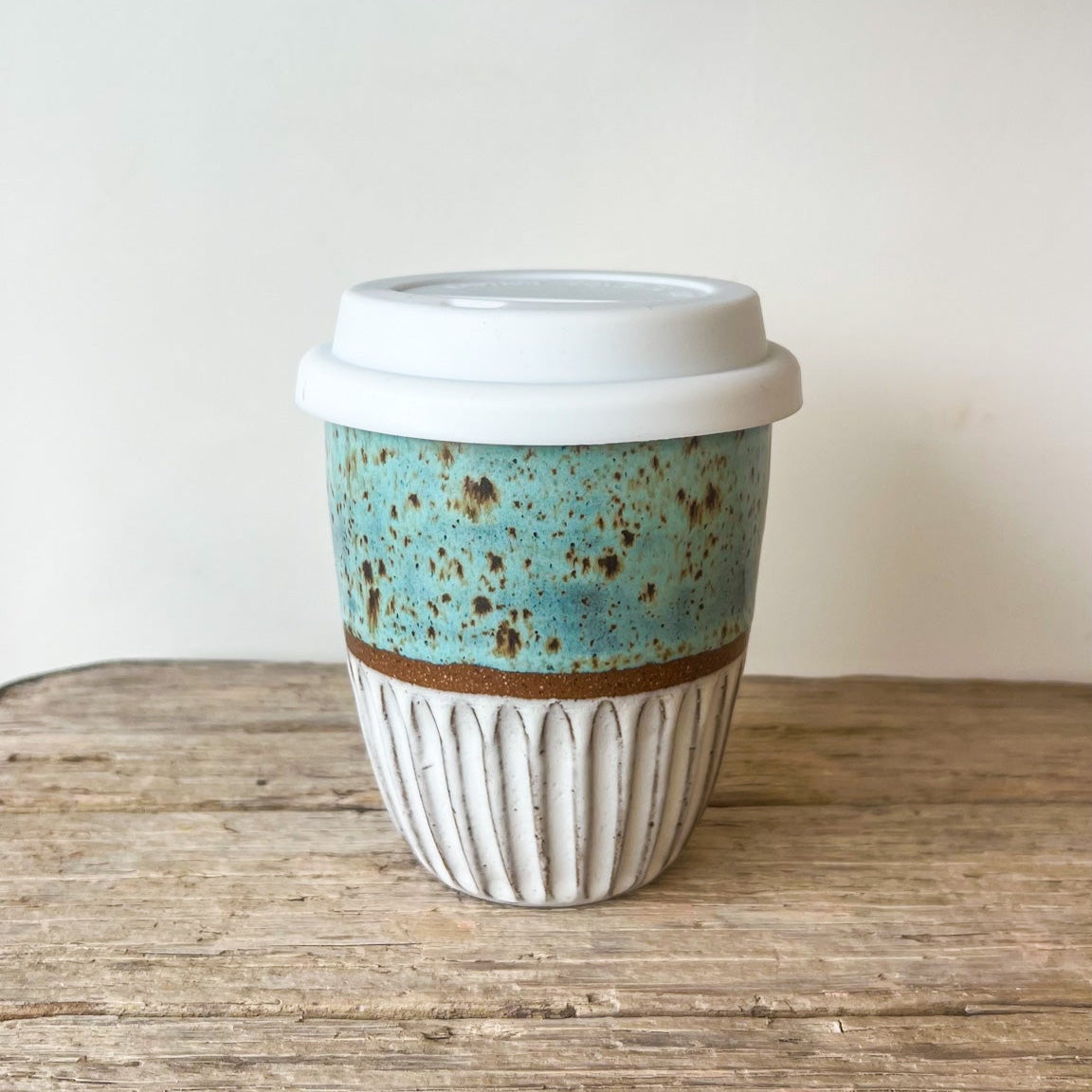 Ceramic coffee cup with a textured design on a wooden surface