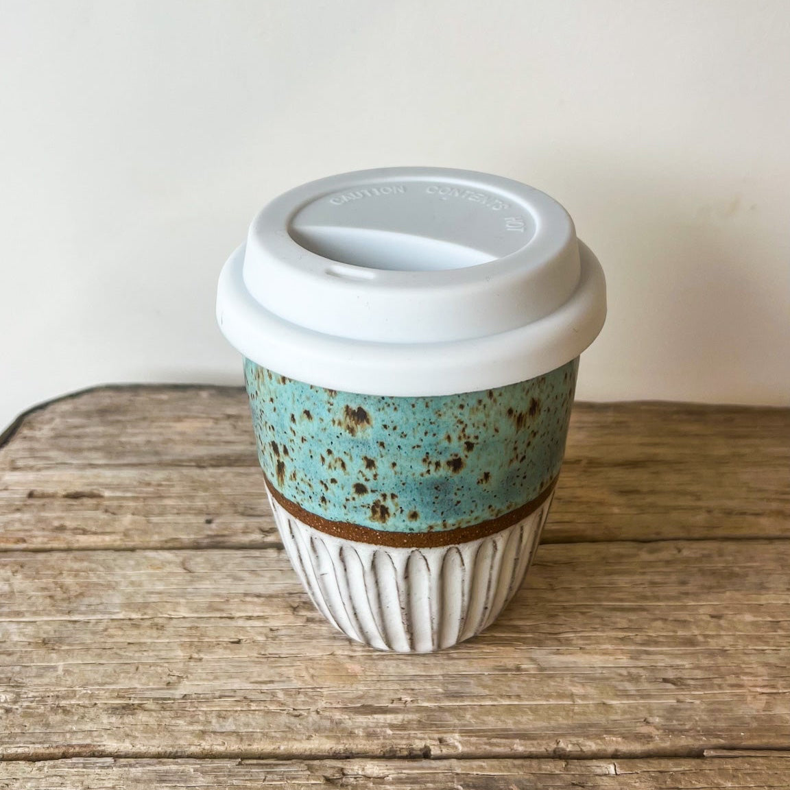 Ceramic coffee cup with a blue pattern on a wooden surface