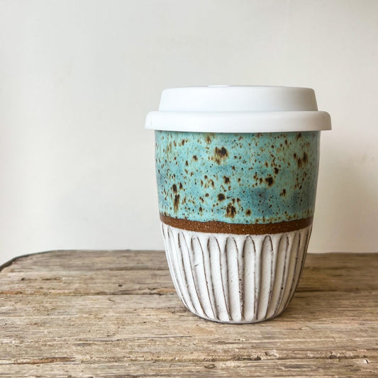 Ceramic cup with a blue and brown design on a wooden surface