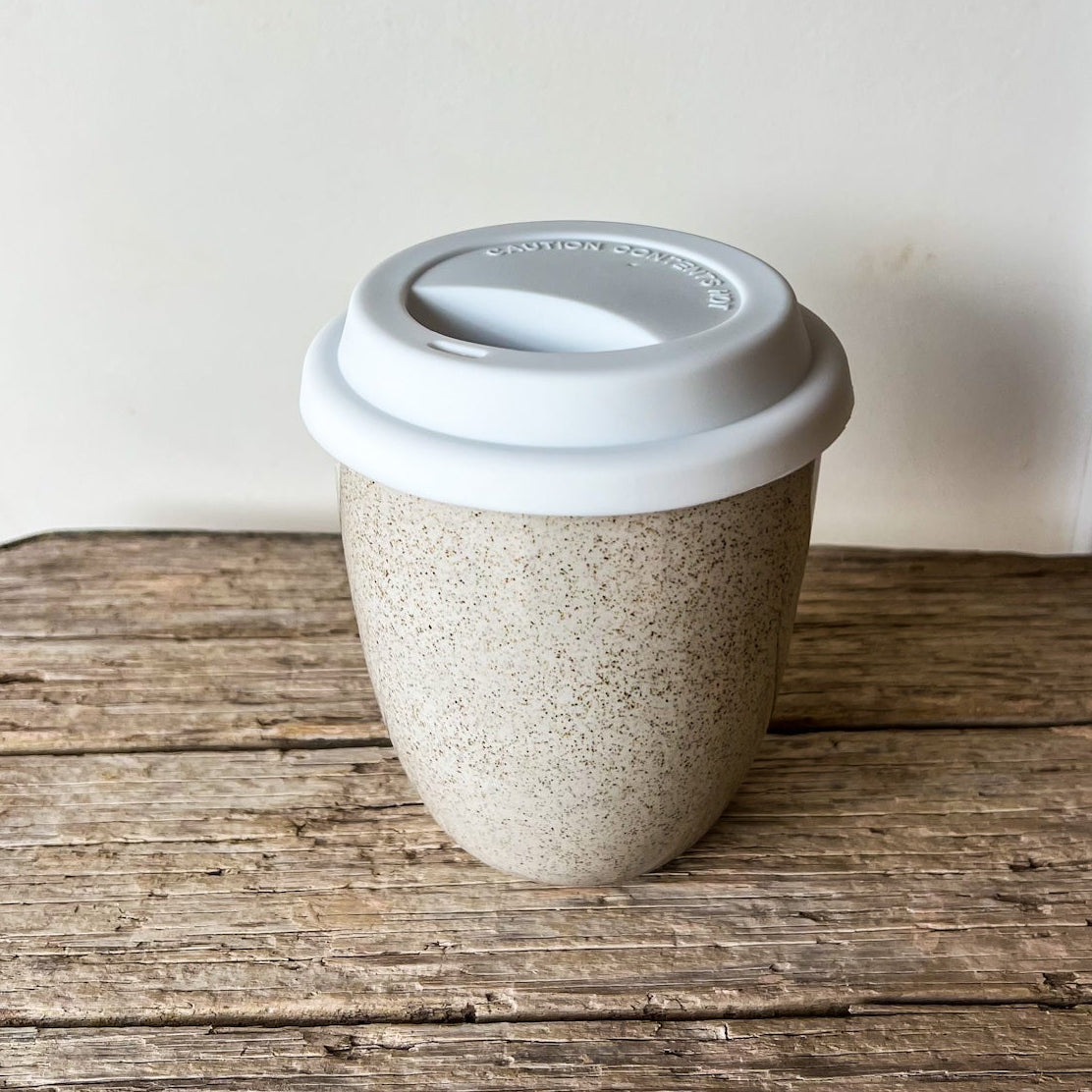 Reusable coffee cup with a white lid