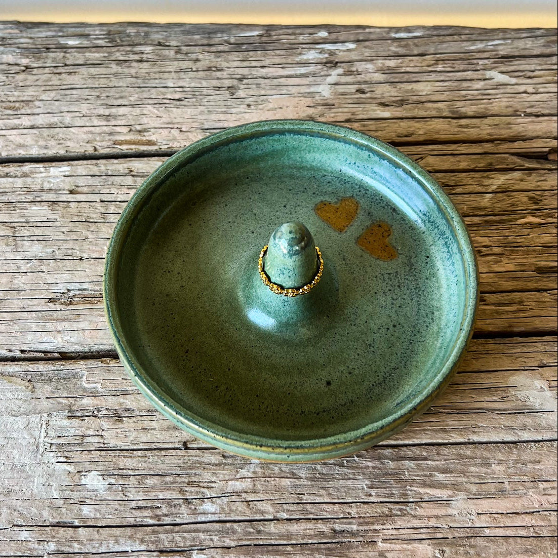 Green ceramic incense burner on a wooden surface