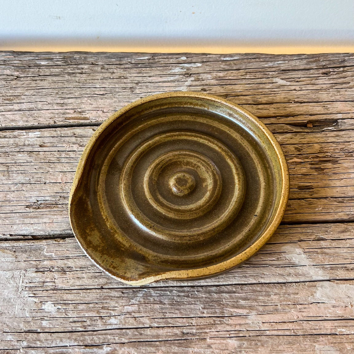 Ceramic bowl with concentric circle pattern on a wooden surface