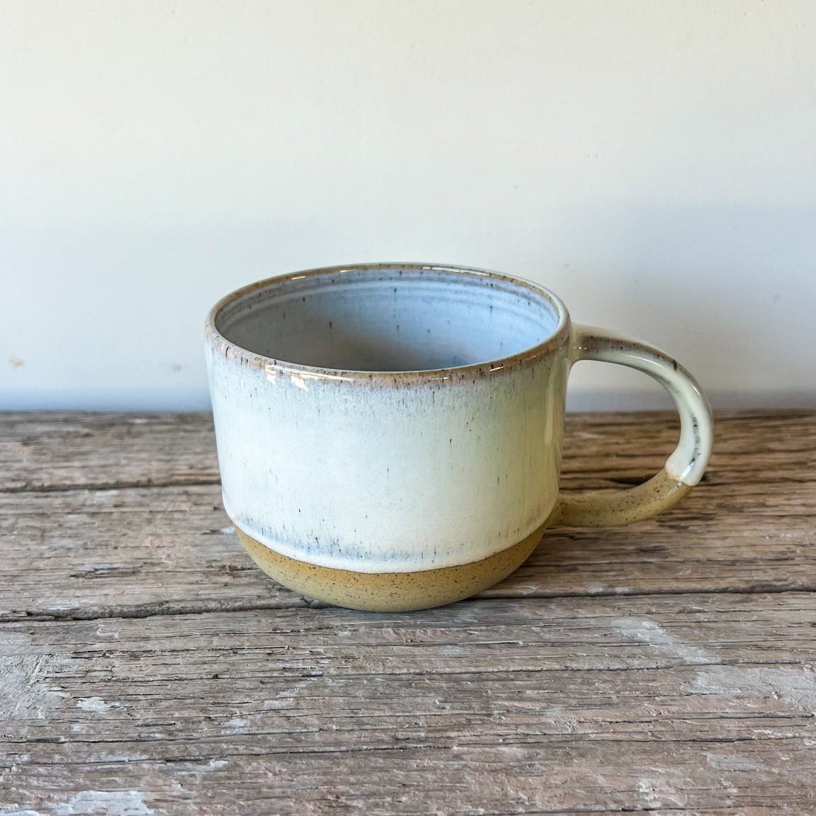 Ceramic mug on a wooden surface with a neutral background