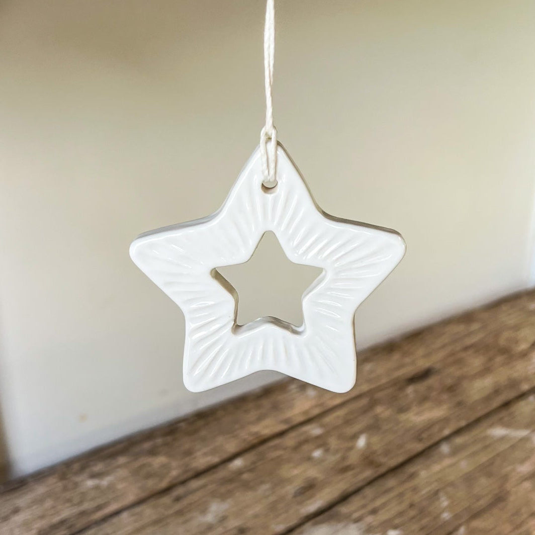White star-shaped ornament hanging on a wooden shelf