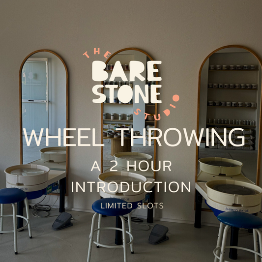 Wheel throwing class setup with mirrors and stools in a studio, featuring 'The Bare Stone Studio' branding.